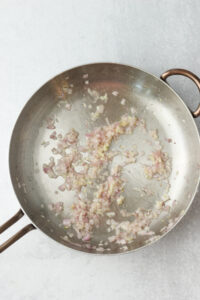 Sautéing the onions and garlic in a large frying pan.