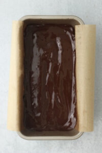 The melted chocolate has been poured and smoothed over the caramel layer.