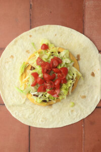 The tomatoes have been added to the Crunchwrap.