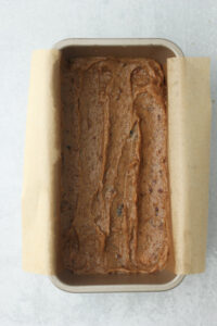 The date caramel has been spread into an even layer over the baked cookie layer.