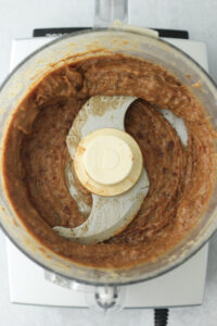 The caramel date mixture has been blended until creamy in a food processor.