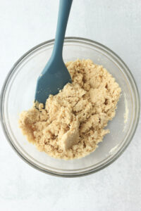 All of the cookie layer ingredients have been mixed in a glass bowl until a dough formed.