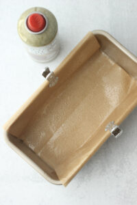 The bread pan has been lined with parchment paper and greased with coconut oil.