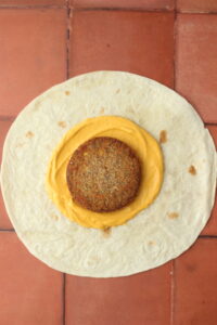 The veggie patty has been added on top of the cashew sauce.