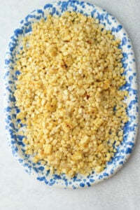 The corn kernels have been added to a large, blue serving dish.