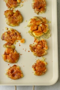 The smashed potatoes have been brushed with a spicy paste.