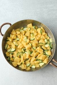 The polenta and zucchini pieces have been sautéed in a pan with avocado oil.