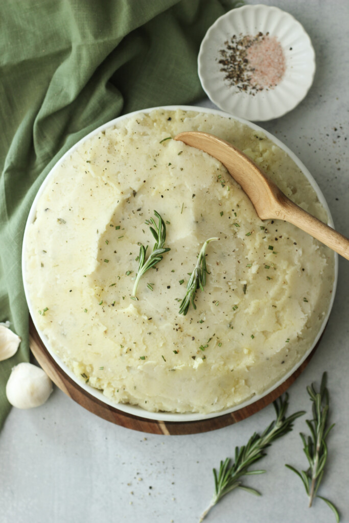 A large white bowl of vegan herb mashed poatoes.