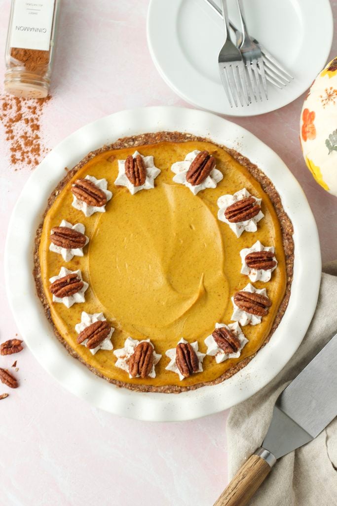 The pumpkin pie is topped with dallops of whipped cream and candied pecans.