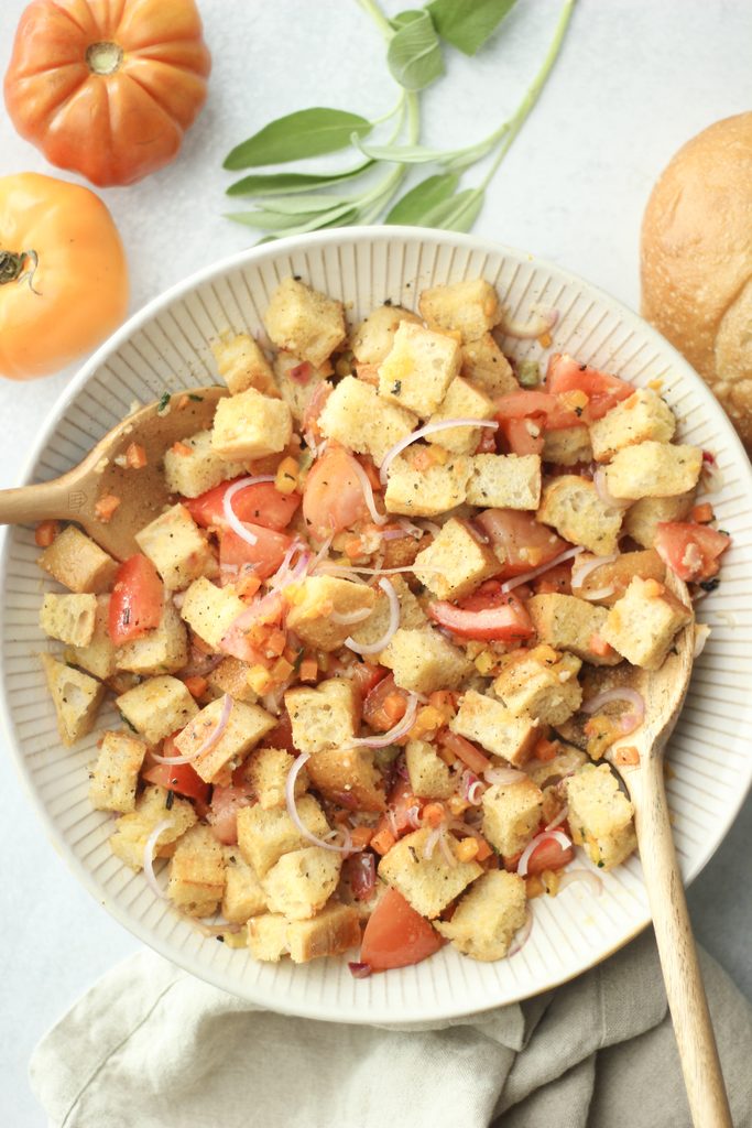 The vegan fall panzanella salad is in a large gray salad bowl and has just been tossed.
