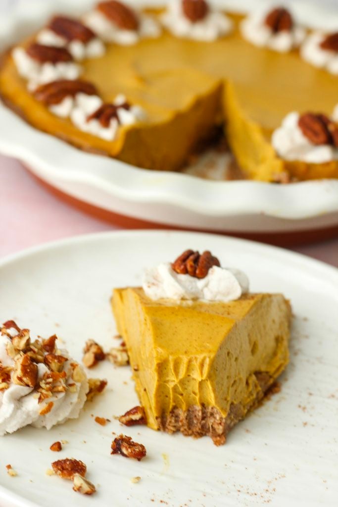 A bite out of a slice of pumpkin pie.