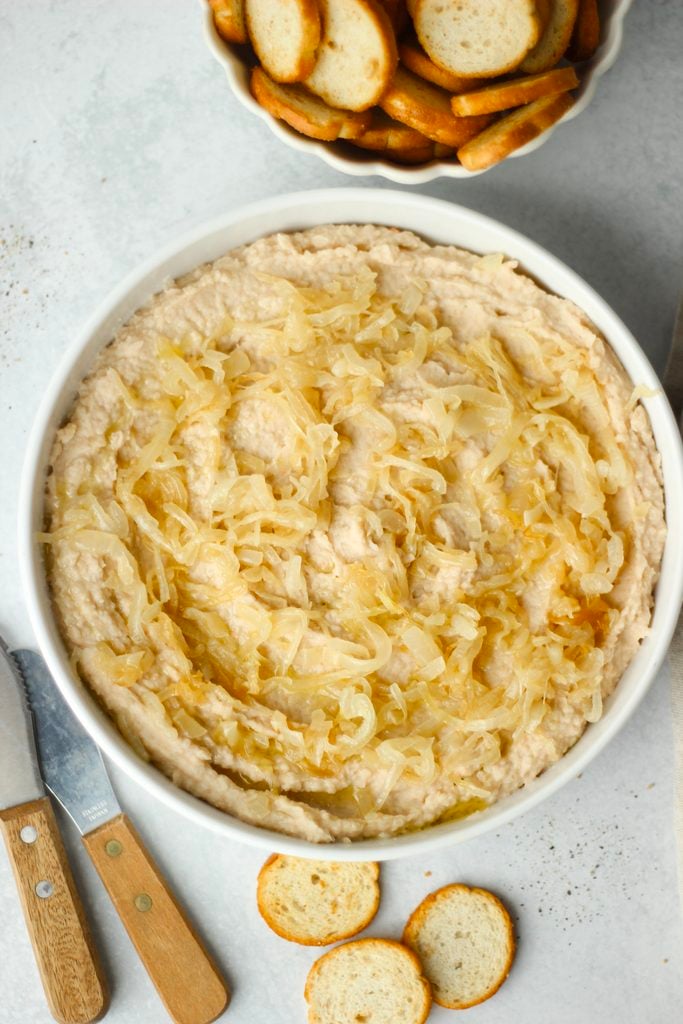 The dip is in a white bowl and is served with crackers.
