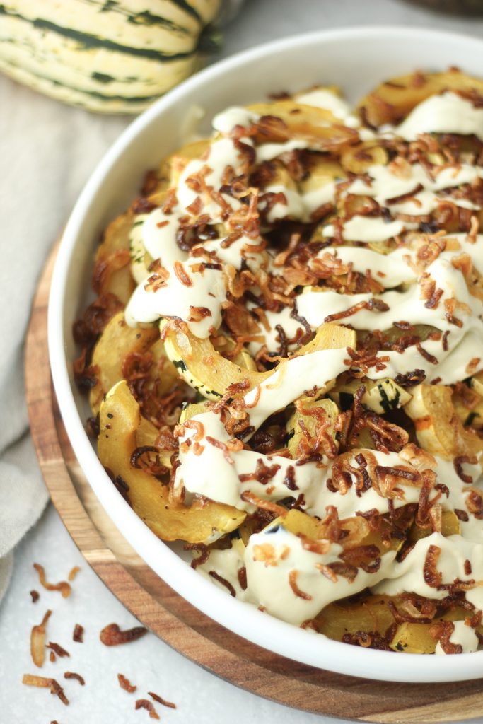 The roasted delicata squash has been topped with sage crema and crispy shallots.